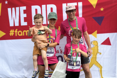 A family  in front of the We Did It! banner