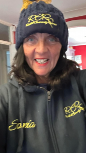 Picture of Sonia facing the camera, wearing Redditch Community Runners bobble hat and fleece